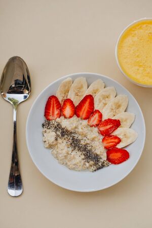 Bowl of breakfast muesli decorated with banana, strawberry slices and chia seed, top view.の写真素材