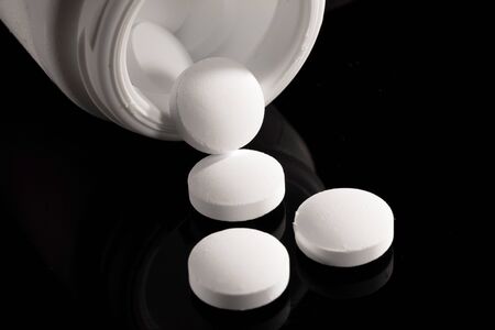 Pharmacy background on a dark table. Levitation pills. Tablets on a dark background which falling down. Pills. Medicine and healthy. Close up of capsules. Pills falling on black background&の写真素材