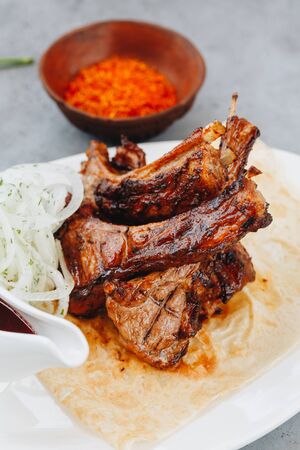 Pork ribs and tomato sauce on white plate. Close up view.の写真素材