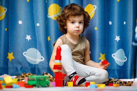 Little autistic boy playing with cubes at home.の写真素材