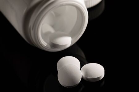 Pharmacy background on a dark table. Levitation pills. Tablets on a dark background which falling down. Pills. Medicine and healthy. Close up of capsules. Pills falling on black background&の写真素材
