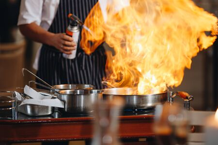The chef prepares food in front of the visitors in the restaurantの写真素材