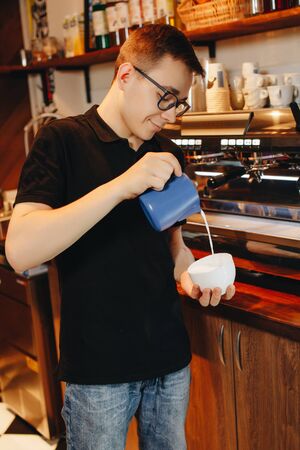 Barista man makes cappuccino in the bar.の写真素材