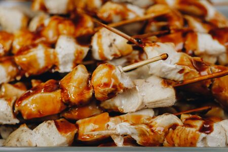 pieces of chicken in a sauce on wooden skewers. close up. の写真素材