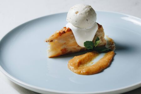 dessert pie with ice cream on a blue plateの写真素材