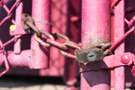 Old lock and chain on a pink fenceの写真素材