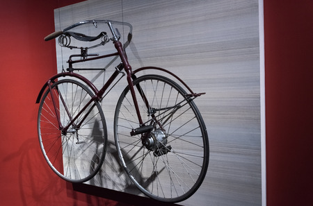 Big bicycle handing on a white wallの写真素材