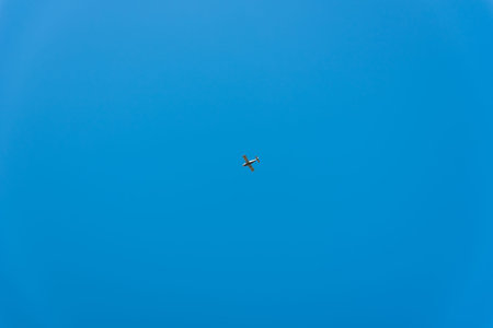 Small plane flying across the blue sky