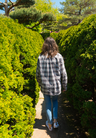 Woman walking in the alley of a botanic gardenの写真素材