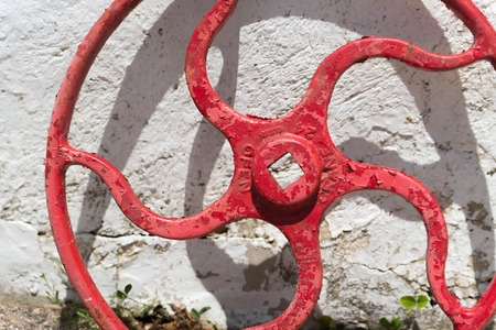 Big metal crane wheel standing next to a buildingの写真素材