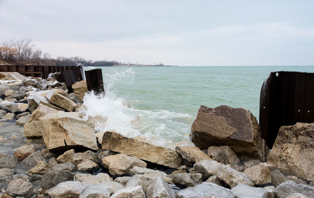Lake water hitting the rocks on a cold winter dayの写真素材