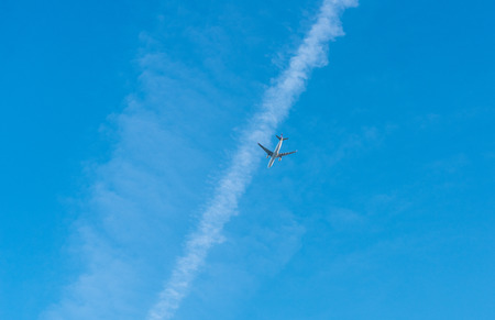 Big white airplane flies in a blue skiesのeditorial素材