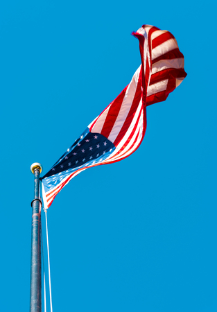 American flag waving on a clear blue skyの写真素材