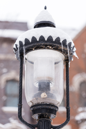 Glass and metal street lamp under a snowの写真素材