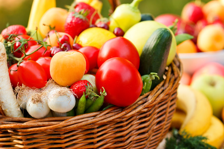 Organic fruits and vegetables in wicker basketの写真素材