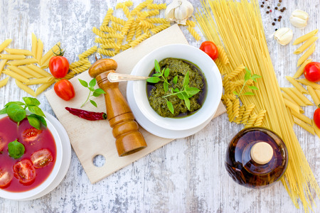 Basil pesto sauce, tomato sauce and ingredients for healthy, delicious mealの写真素材