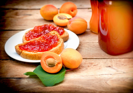Apricot jam on bread, tasty meal (breakfast)の写真素材