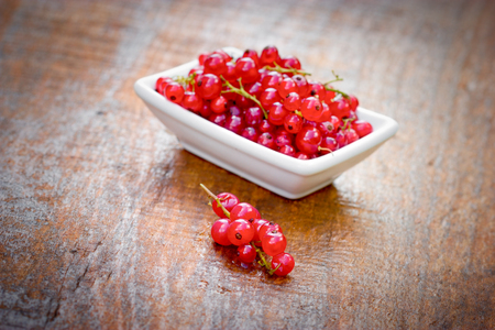 Red currant, organic currants on table and in white bowlの写真素材