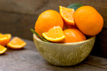 Delicious and juicy orange, organic oranges in bowl on tableの写真素材