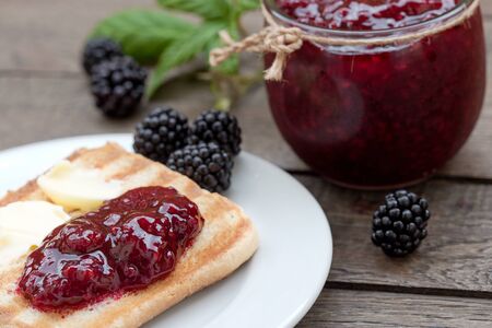 Blackberry marmalade (jam) and butter on toastの写真素材
