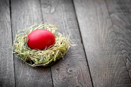 Red easter egg in nest, a symbol of life, a symbol of faith and Christianityの写真素材