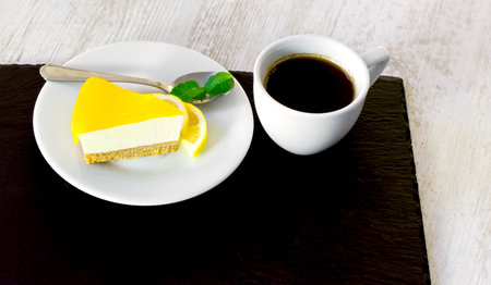 Cheesecake and coffee on table, delicious lemon cakeの写真素材