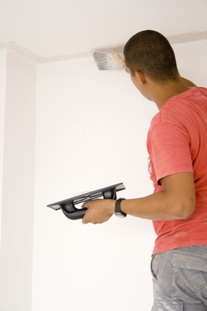 Worker repairing the ceiling with plaster. With some noise.の写真素材