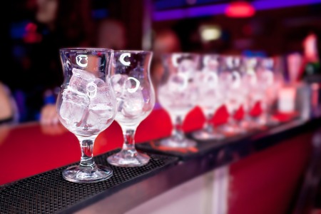 Glasses with ice on the bar counter at a nightclubの写真素材
