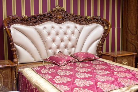 Double bed with decorative headboard.の写真素材