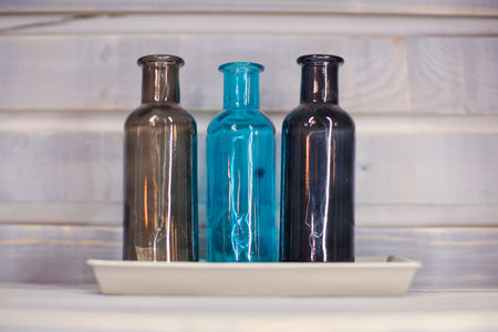 Three colored decorative bottles a blue background.