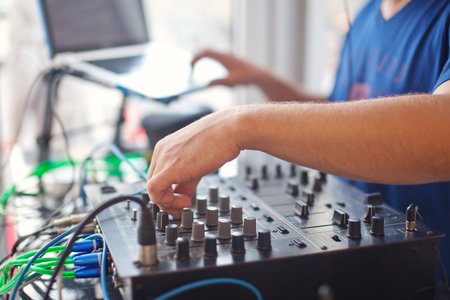 DJ mixing music on console at the night club.