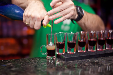 The bartender makes a cocktail shot.