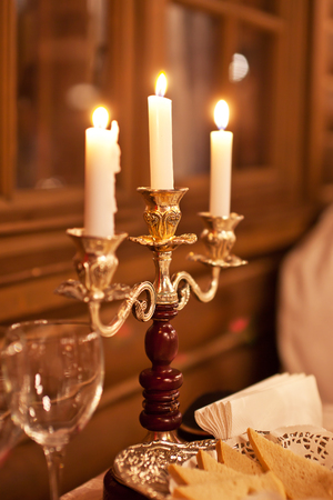 The burning candles in a candlestick on a festive table.の写真素材