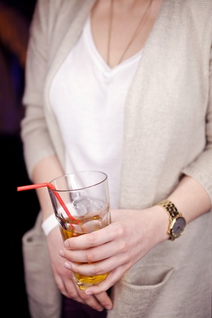Glass with a drink in the hands of women.の写真素材