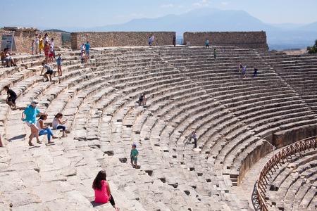 PAMUKKALE, TURKEY - September 13, 2015: Tourists regard antique amphitheater in the ancient city of Hierapolis. Pamukkale, Turkey.のeditorial素材