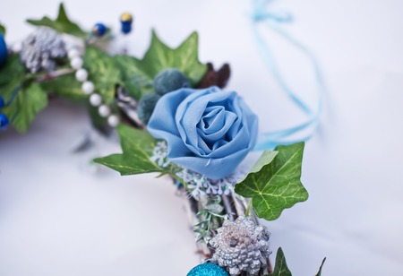 Christmas decorative wreath with ivy leaves, artificial flowers and beads. Fragmentの写真素材