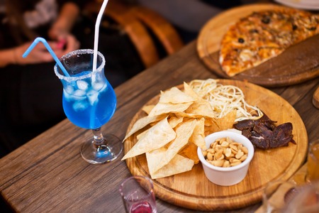 Totapo chips with salt nuts and blue drink.の写真素材