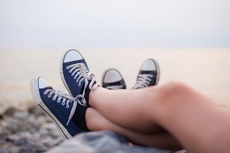 The legs of a guy and a girl in the evening on the beach.の写真素材