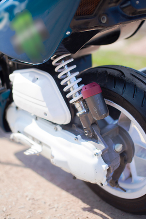 Rear wheel of blue modern scooter on the gravel road.の写真素材