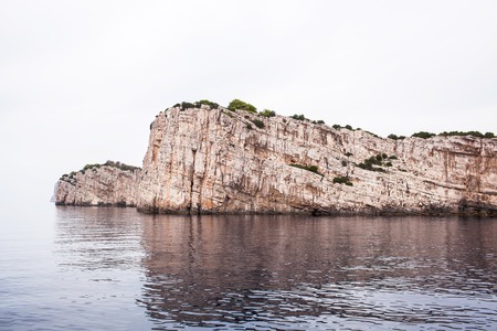 A large stone wall of beige stone in the sea.の写真素材