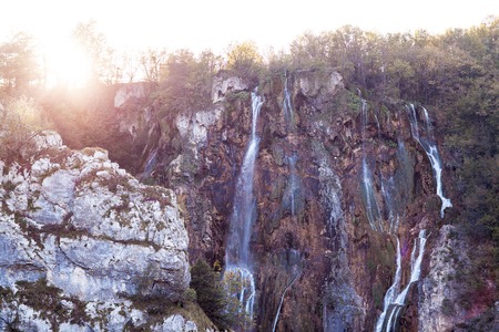 Water that falls from a large waterfall over stone slopes, Plitvice Lakes.の写真素材