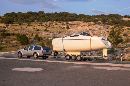 Car pulls yacht on trailer.の写真素材