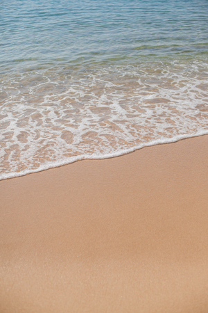 Soft wave of the sea on the sandy beach verticalの写真素材