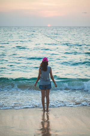 romantic woman from the back in summer vacations on the beach sunset verticalの写真素材
