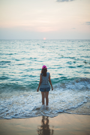 romantic woman from the back in summer vacations on the beach sunset verticalの写真素材