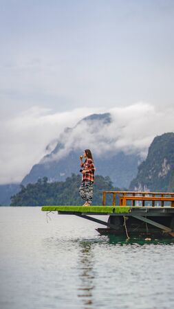 A woman do yoga over the lakeのeditorial素材