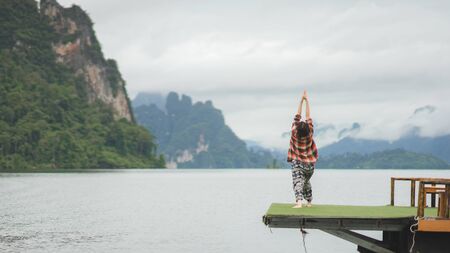 A woman do yoga over the lakeのeditorial素材
