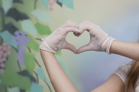 detail of gloved hands of a communion girl marking the heart shapeの写真素材