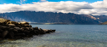 Mountains towering over Queenstown lakeの写真素材