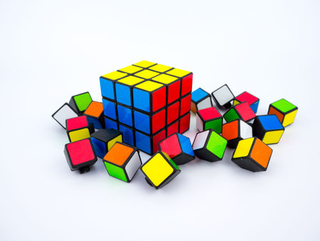 Bangkok, Thailand - October 27th, 2016: Colorful Rubik's cube and broken cube pieces on white...